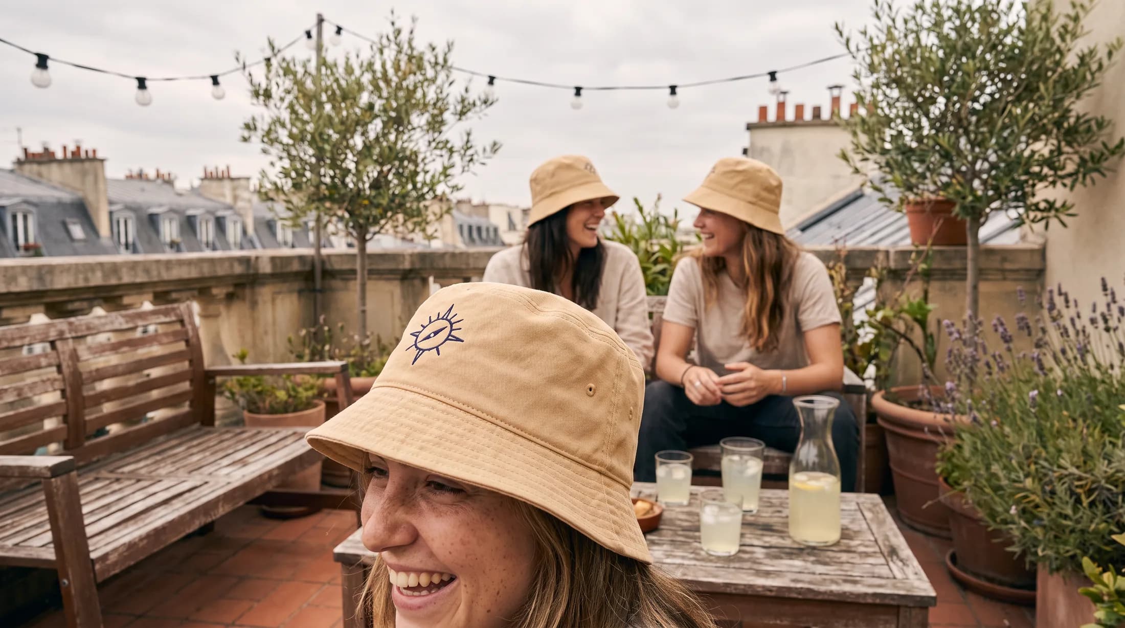 Petit groupe portant des bobs brodés assortis en terrasse à Paris