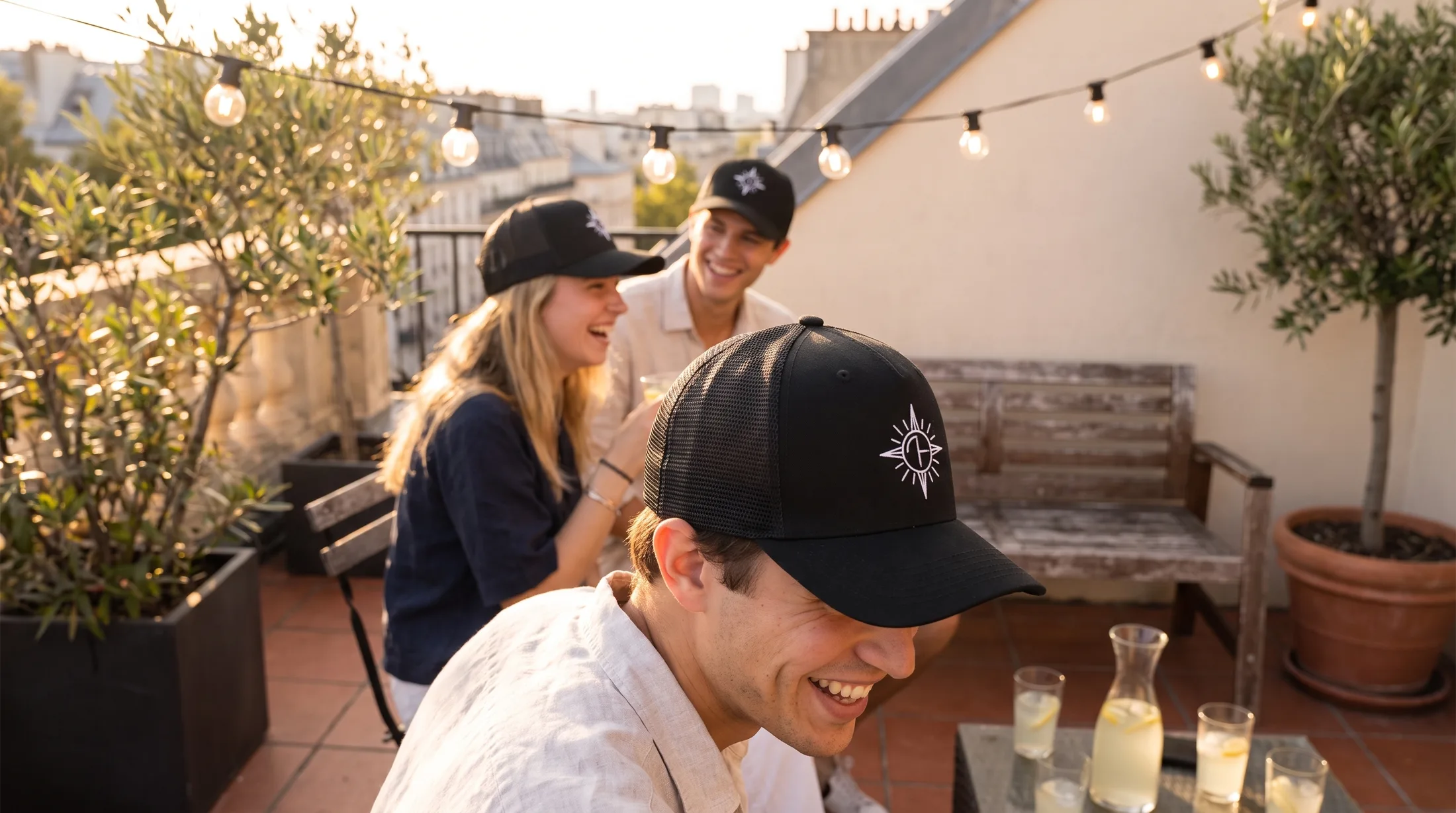Petit groupe portant des casquettes trucker noires brodées assorties en terrasse à Paris